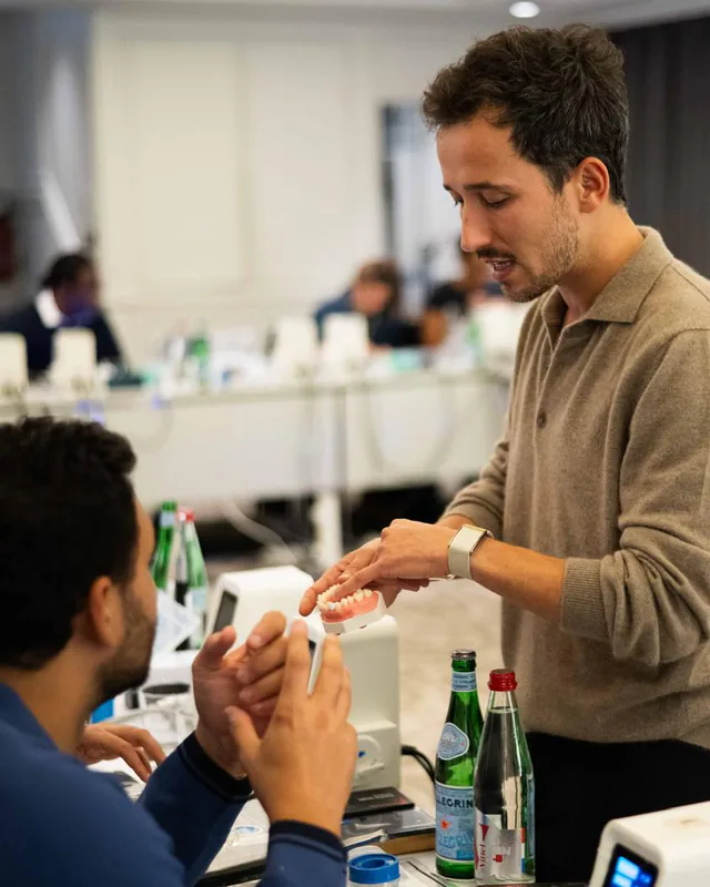 Le Dr Jérémy Haccoun présente un modèle dentaire lors d’une formation au composite injecté.