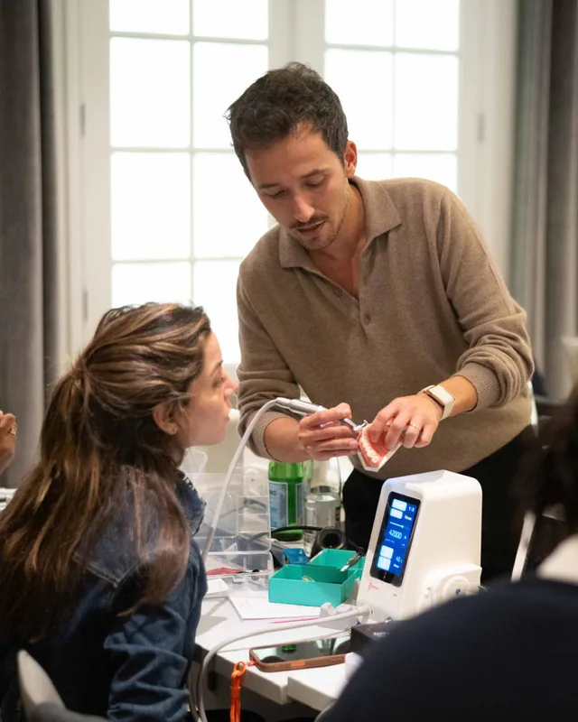 Le Dr Jérémy Haccoun accompagne une participante pendant un atelier sur les facettes en composite.