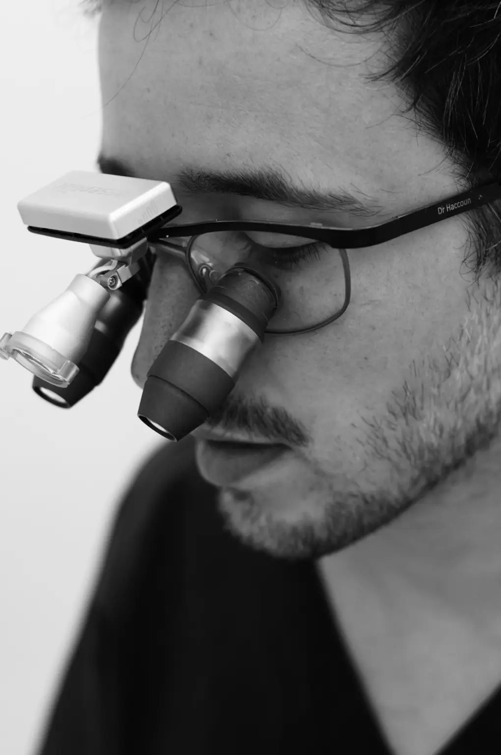Dr Jérémy Haccoun travaillant avec des loupes grossissantes